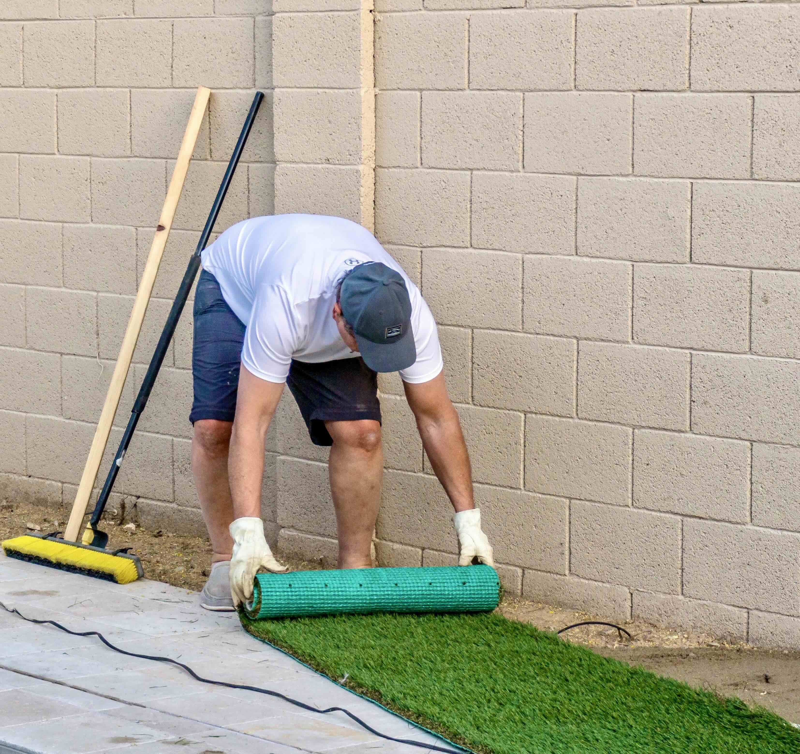 adult male installing artificial grass turf