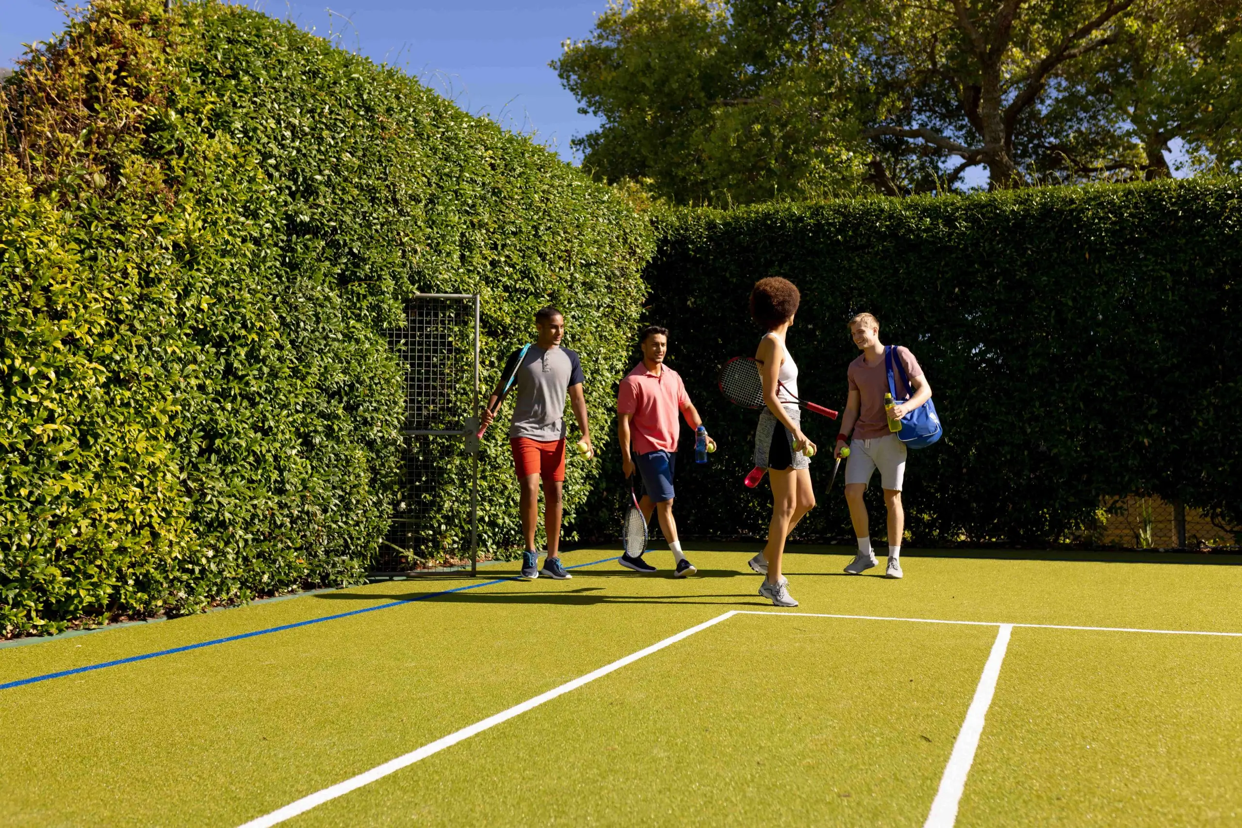 group of friends playing tennis on artificial grass